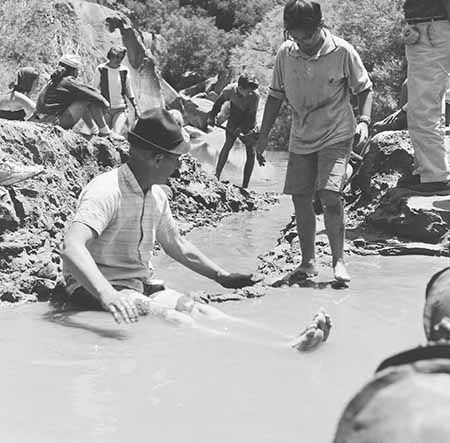 David Brower sitting in Colorado River mud