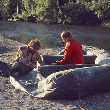 In late August, the Tatshenshini was a modest stream at the put in. Note that Marida is using a very small hand pump. The raft was a "Yampa" produced by Rubber Fabricators, Inc. in Virginia designed to replicate a WWII assault raft but made with nylon and neoprene rather than cotton and neoprene.
